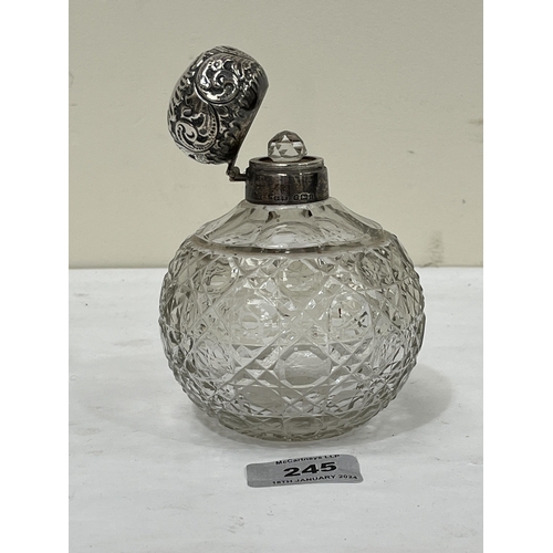 245 - An Edward VII globular cut glass scent bottle with silver mount and repousse lid. Birmingham 1903. 5... 