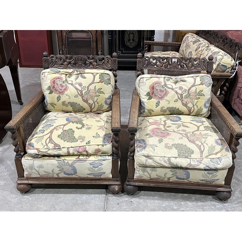 362 - A 1930s oak carved bergere three piece sofa suite comprising a sofa (break to back) and a pair of ar... 