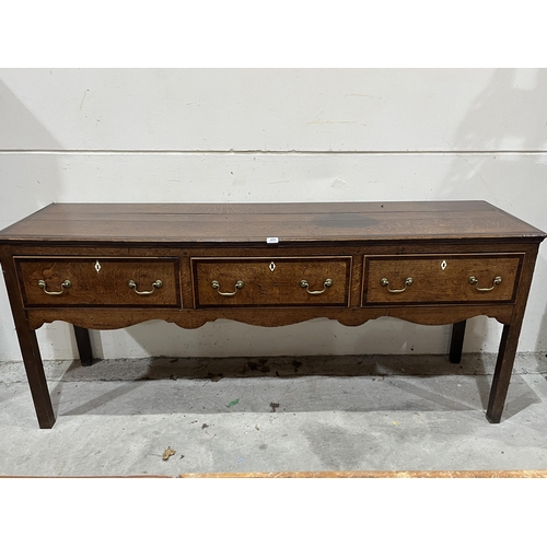 435 - A George III oak and mahogany crossbanded low dresser with three drawers on square legs 73