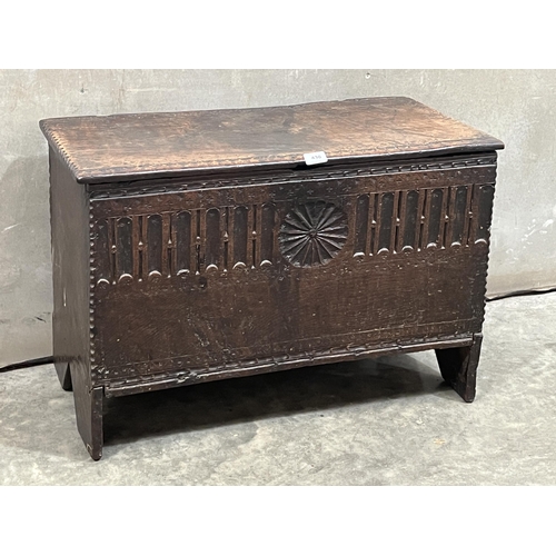 438 - A Charles II chip carved boarded oak chest, the front carved with a patera flanked by fluted arcade.... 