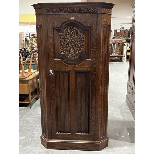 453 - A 1930s oak hall robe enclosed by a linen carved door. 36