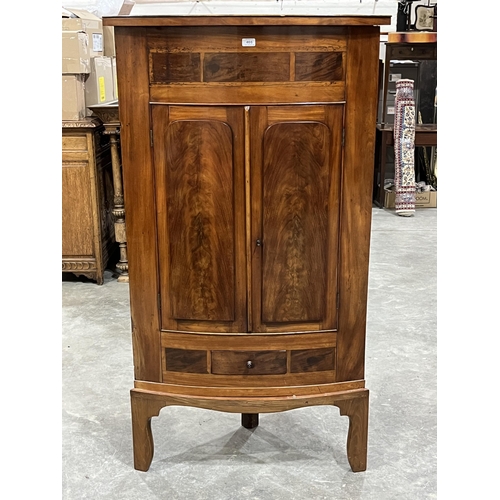 466 - A 19th century mahogany bow-fronted standing corner cupboard. 62