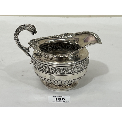 180 - A 19th Century silver helmet form milk jug, the gadrooned body with a border of scrolled foliage and... 