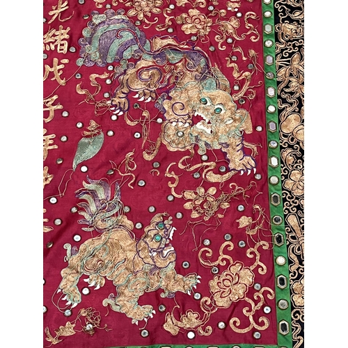 194 - A Chinese polychrome silk hanging worked with gilt and other coloured threads and mirrored appliques... 