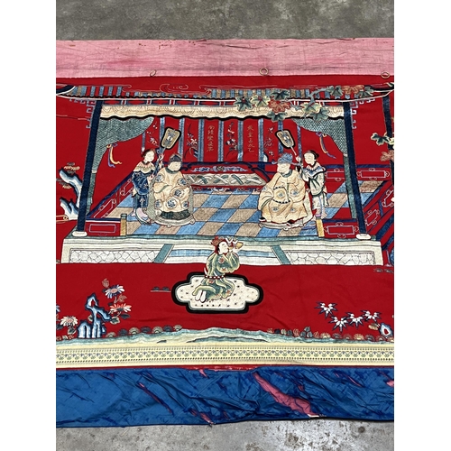 195 - A Chinese polychrome silk hanging worked in coloured threads with figure groups, buildings, trees an... 