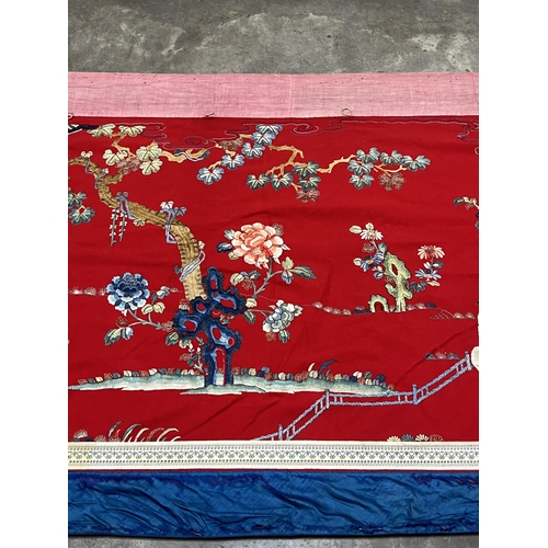 195 - A Chinese polychrome silk hanging worked in coloured threads with figure groups, buildings, trees an... 