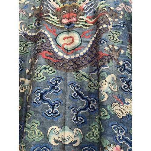 196 - A Chinese polychrome silk robe, decorated with with dragons and auspicious objects. 55' long