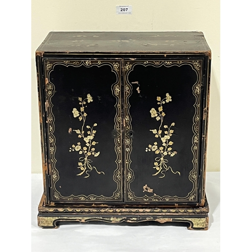 207 - A 19th Century Oriental lacquer table cabinet on stand, decorated with gilt flowers, the pair of doo... 