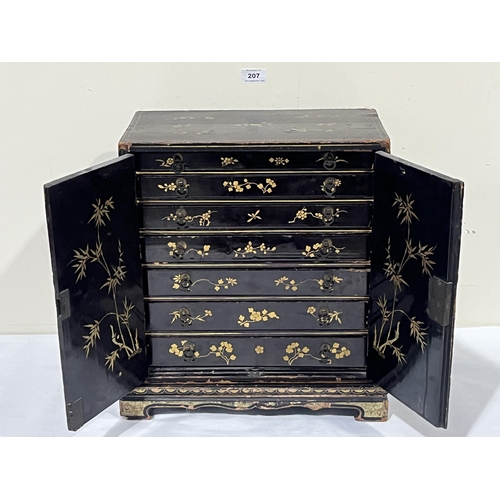 207 - A 19th Century Oriental lacquer table cabinet on stand, decorated with gilt flowers, the pair of doo... 