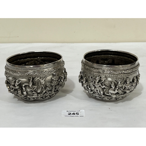 245 - A pair of Indian silver bowls, decorated in high relief with continuous figure scenes or figures in ... 