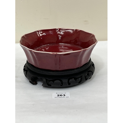 263 - A Chinese sang-de-boeuf bowl on wood stand. 7½