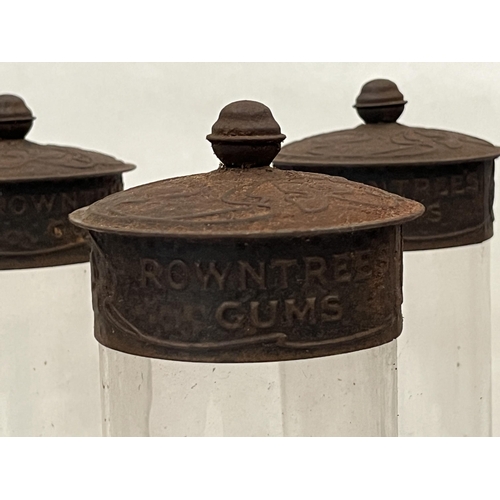 439 - Seven Rowntree Gums glass jars with embossed metal covers. 11½