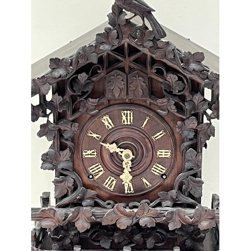 101 - A late 19th Century Bavarian quarter striking 'Cuckoo and Quail' table clock, in chalet style oak ca... 