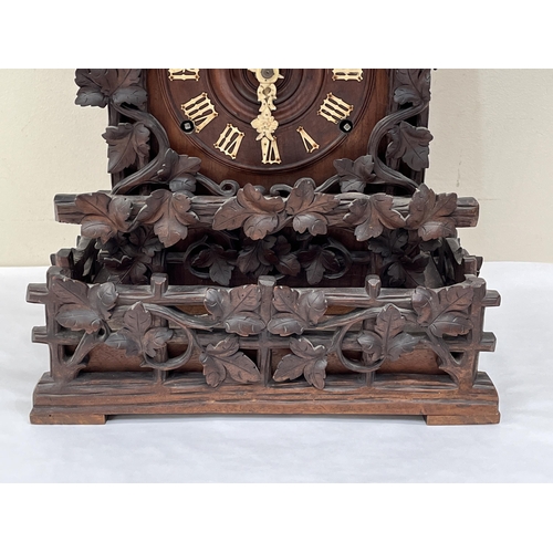 101 - A late 19th Century Bavarian quarter striking 'Cuckoo and Quail' table clock, in chalet style oak ca... 