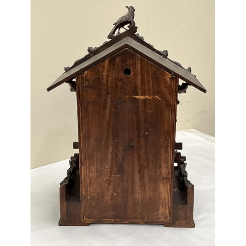 101 - A late 19th Century Bavarian quarter striking 'Cuckoo and Quail' table clock, in chalet style oak ca... 