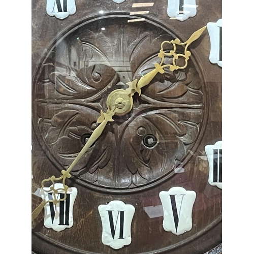 102 - A late 19th Century Black Forest type oak wall clock with two train spring barrel movement striking ... 