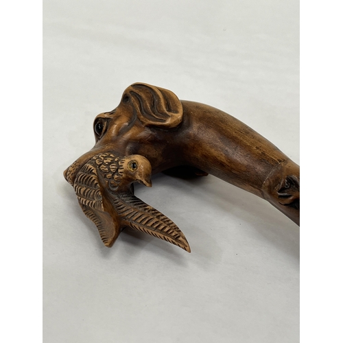 150 - An Edward VII blackthorn walking cane, the pommel carved as a glass eyed hound's head with gamebird,... 