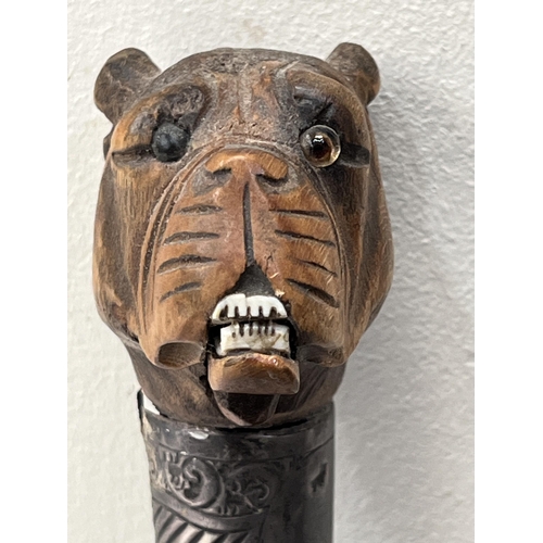 151 - A Victorian walking cane with silver collar (split); the boxwood pommel carved as a bulldog head wit... 