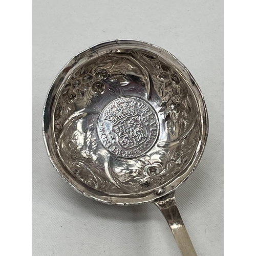 155 - A silver toddy ladle with whalebone handle, the repousse decorated bowl with inset 18th Century Span... 