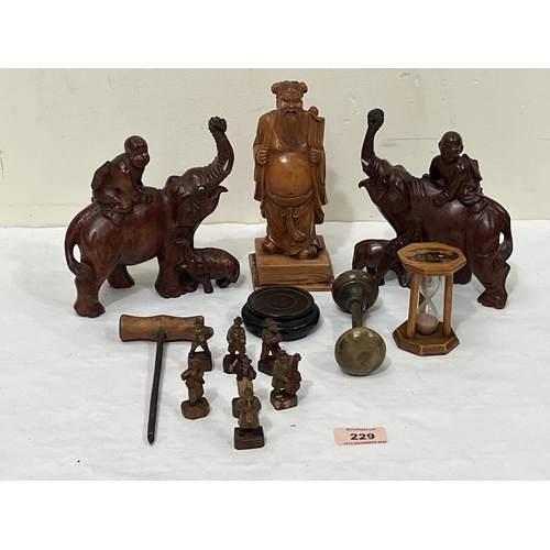 229 - A box of carved treen and metalware to include a figure of a sage, Maucheline ware egg timer, a sept... 