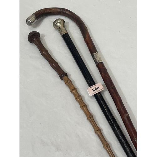 246 - A silver mounted walking stick; another with white metal pommel and a military bamboo swagger stick ... 