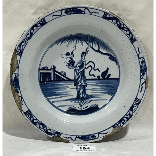 194 - An 18th Century Delft plate decorated in blue and white with an oriental figure in a landscape. 9