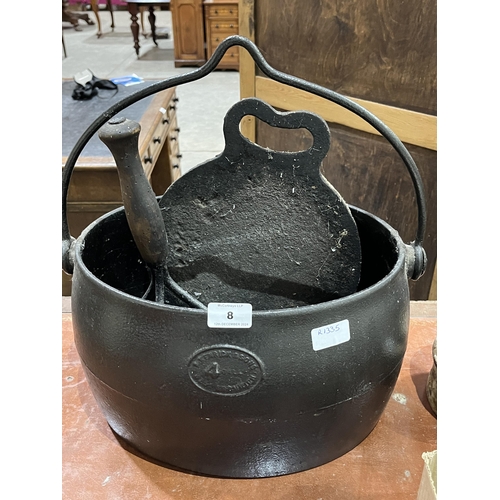 8 - A 4 gallon cast iron cooking pot, a swede masher, a cast iron baking plate and two flat irons.