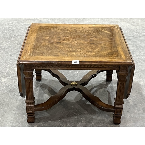 417 - A walnut drop-leaf low table. 24