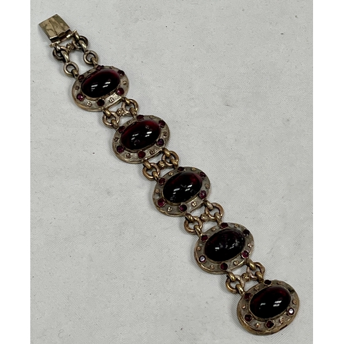 190 - A Victorian gilt medallion link bracelet set with five cabachon garnets and thirty flat cut garnets.... 