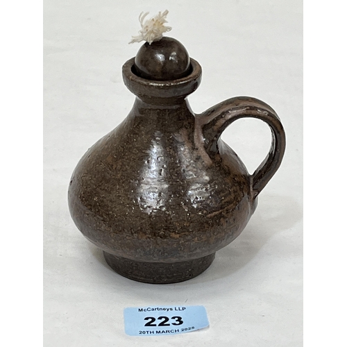 223 - A German studio glazed pottery oil lamp. Signed to base. 4½