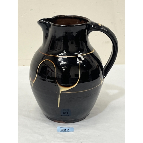 233 - RAY FINCH (FOR WINCHCOMBE POTTERY). BRITISH 1914-2012 A brown glazed jug with trailed decoration in ... 