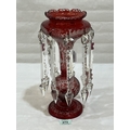 A 19th century etched ruby glass table lustre, hung with prismatic ...