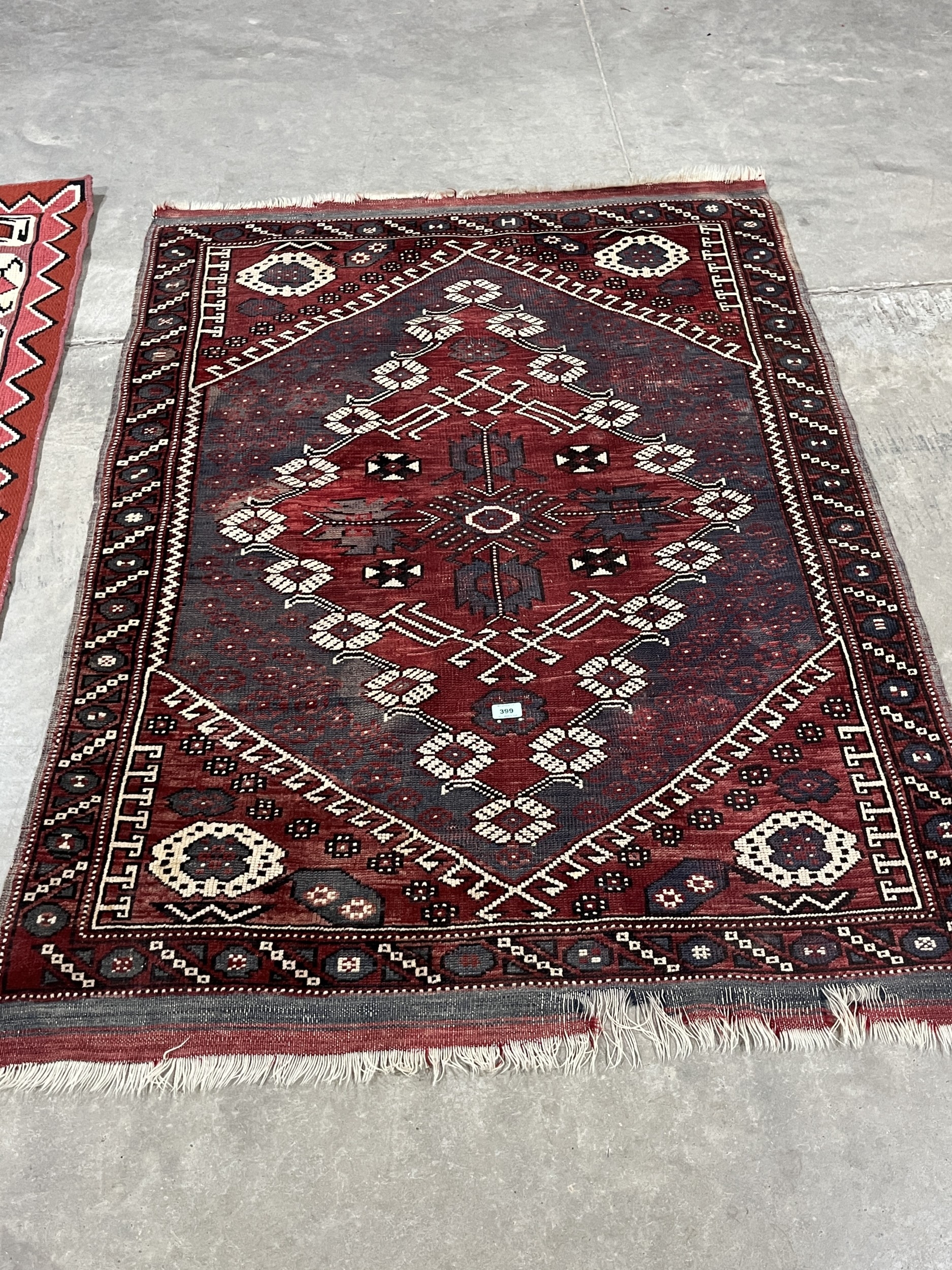 A middle-eastern red ground rug, 62in x 47in and another rug
