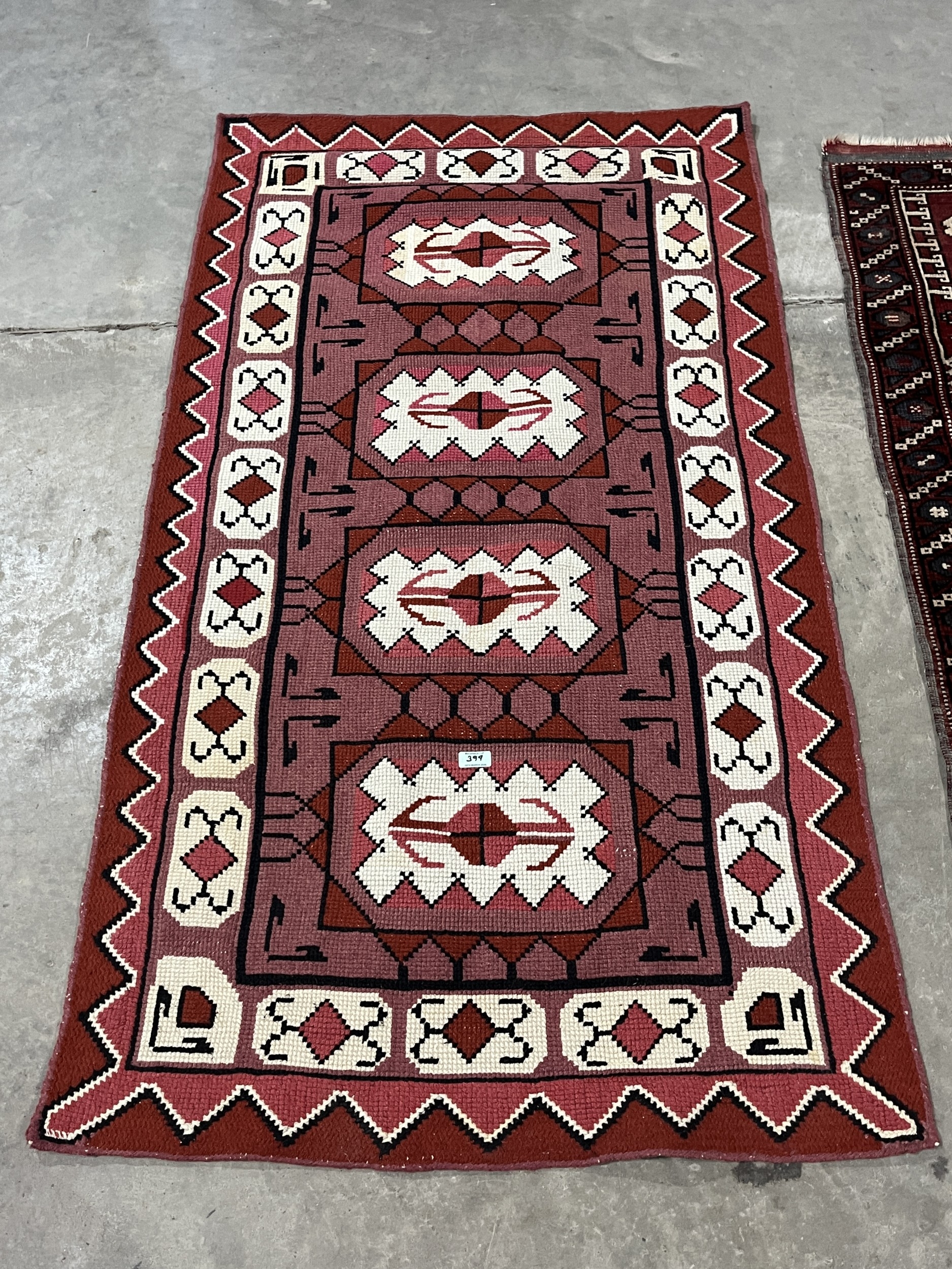 A middle-eastern red ground rug, 62in x 47in and another rug