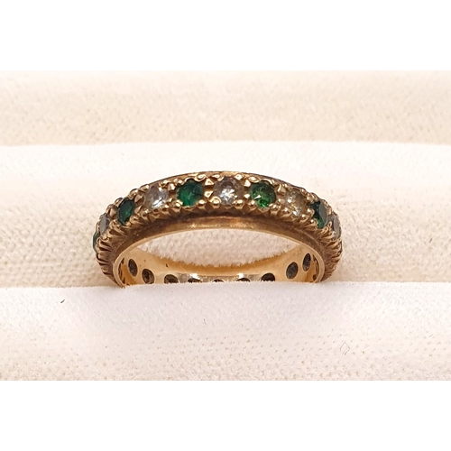 4 - A 9ct yellow gold full eternity ring set with cubic zirconia and green paste stones, 2.48g.  Size of... 