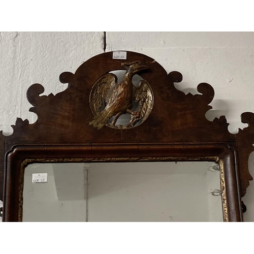35 - Early 19th cent. Mahogany mirror, shaped top with carved gilded ha ha bird and shaped bottom with gi... 
