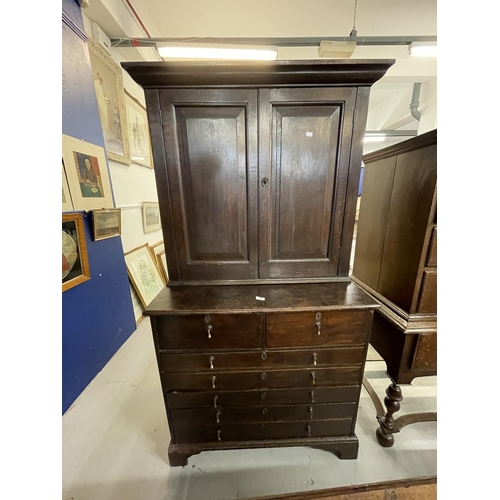 145 - 18th cent. Oak interesting cupboard with two panelled doors and two shelves over a chest of two shor... 