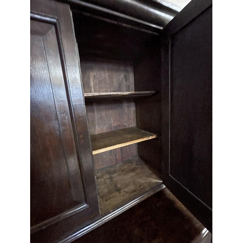 145 - 18th cent. Oak interesting cupboard with two panelled doors and two shelves over a chest of two shor... 