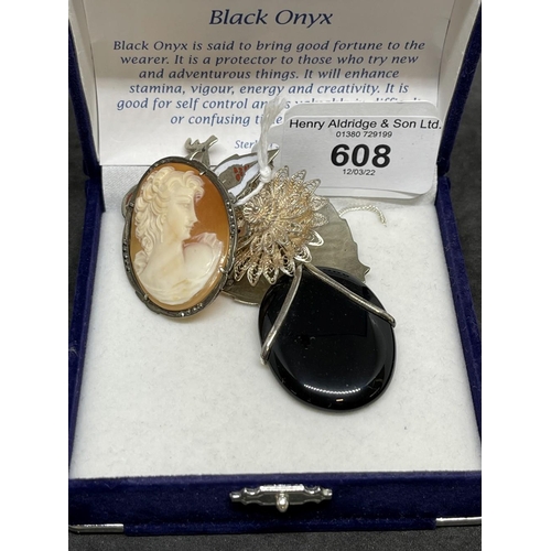 608 - Jewellery: White metal four brooches plus a pendant set with an oval onyx attached to a curb link ch... 