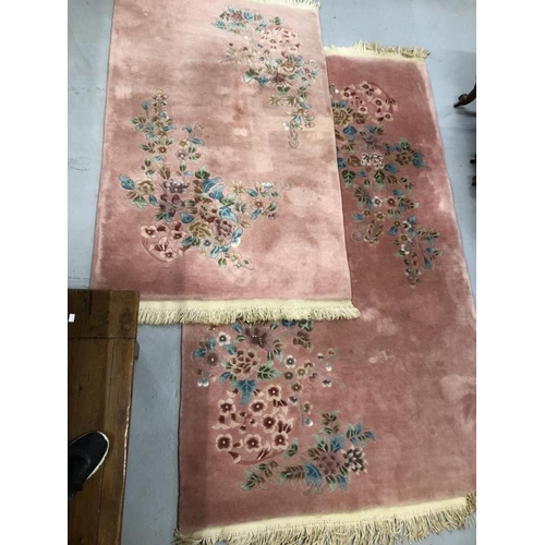 12 - Carpets & Rugs: Chinese hand wash pink ground with blues, reds, greens and browns, a pair. 98ins. x ... 