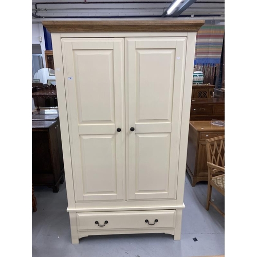 54 - 20th cent. Two door wardrobe with moulded oak cornice above two cream painted doors above a single d... 