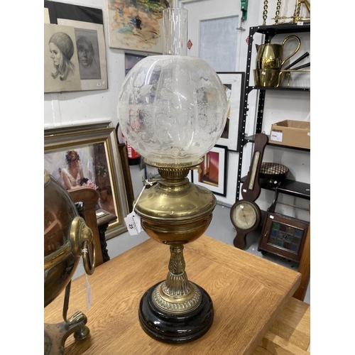 25 - Early 20th cent. Brass oil lamp on a black porcelain mount, topped with a glass chimney and a round ... 