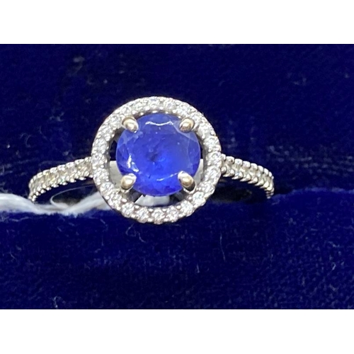 443 - Jewellery: White metal ring in the form of a halo centre set with a circular cut tanzanite, estimate... 