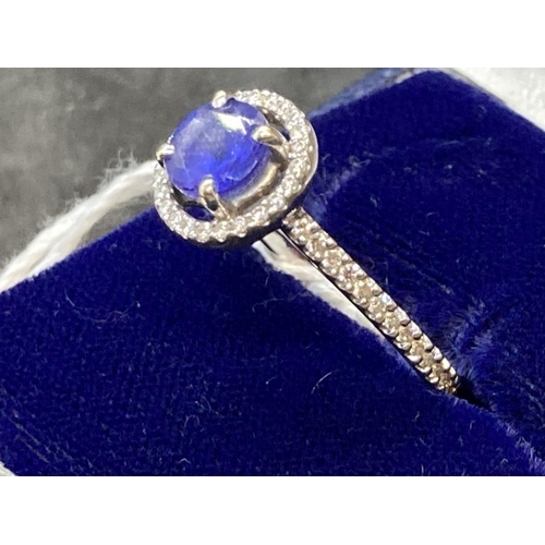 443 - Jewellery: White metal ring in the form of a halo centre set with a circular cut tanzanite, estimate... 