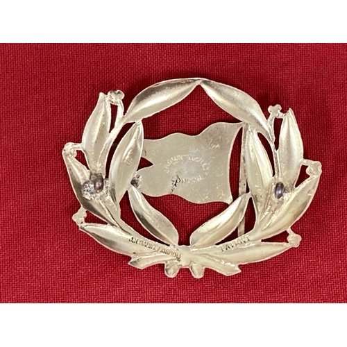 200 - Badges: Gaunt of London gilt cap badge inset with red enamel and Prince of Wales feathers, possibly ... 