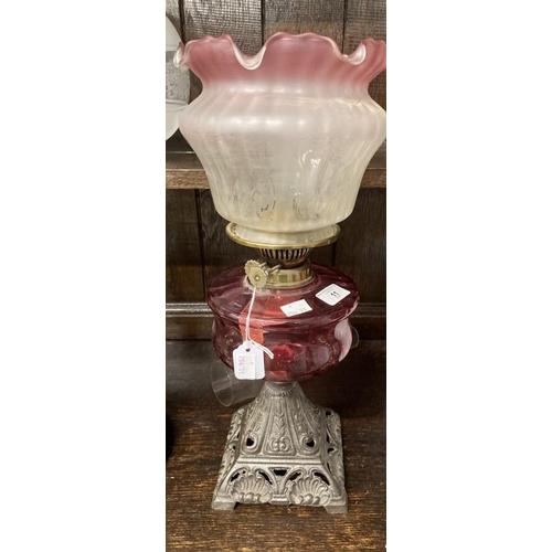 11 - Victorian oil lamp cast iron base, cranberry glass reservoir vase line glass shade. 22ins.