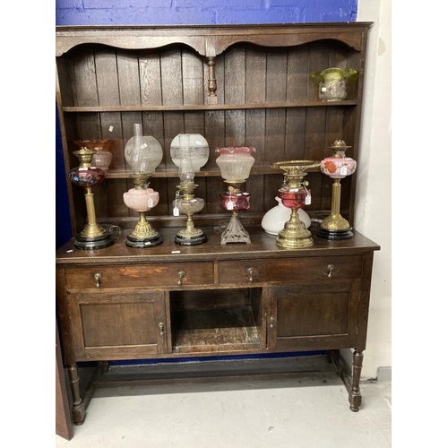 15 - Early 20th cent. Stained oak dresser with two shelves, two drawers and two cupboards on turned suppo... 