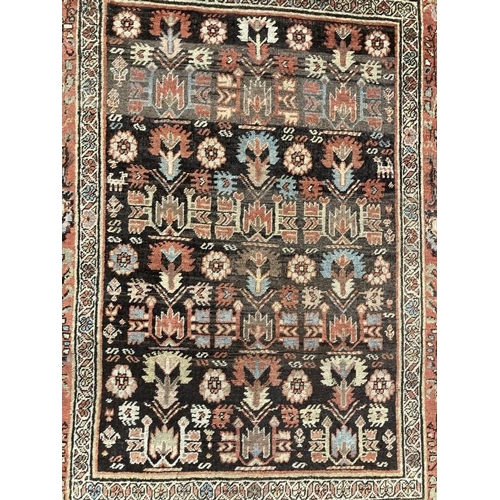 26 - Rugs & carpets: Late 19th cent. Persian rug, black ground central panel decorated with stylised flow... 