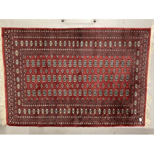 28 - Carpets & Rugs: Late 19th cent. Turkman rug, red ground with a central panel containing sixty guls a... 