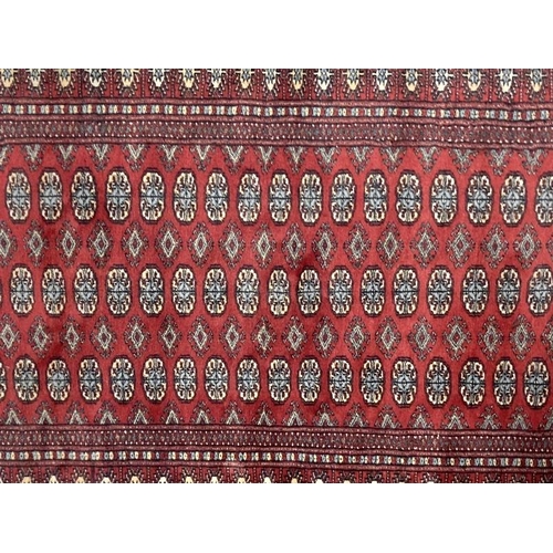 28 - Carpets & Rugs: Late 19th cent. Turkman rug, red ground with a central panel containing sixty guls a... 